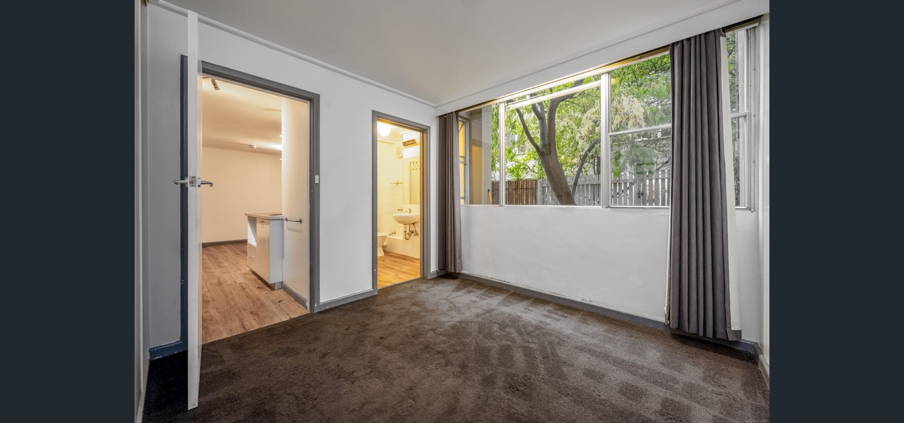 Draft House interior before renovation — carpeted room with bathroom access